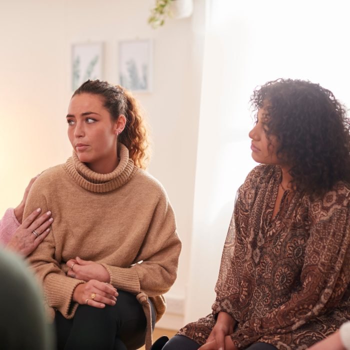 Group Consoling Woman Speaking At Support Group Meeting For Mental Health Or Dependency Issues Group Consoling Woman Speaking At Support Group Meeting For Mental Health Or Dependency Issues